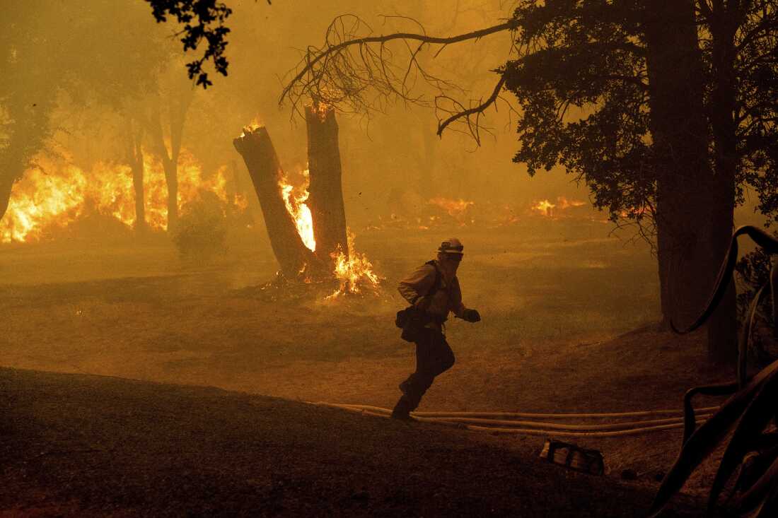 Um bombeiro corre enquanto luta contra o incêndio Thompson em Oroville, Califórnia, na terça-feira.